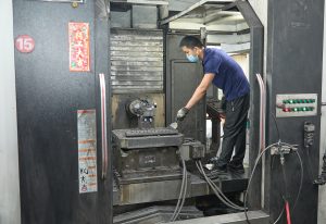 Operator setting up a CNC machining center in the workshop