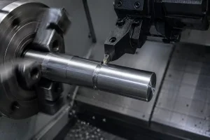 Proceso de mecanizado de ranurado CNC que muestra una herramienta de corte que forma una ranura externa en un eje metálico.
